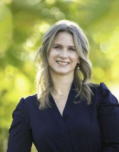 Headshot of Lori Pereira smiling with green blurred background.